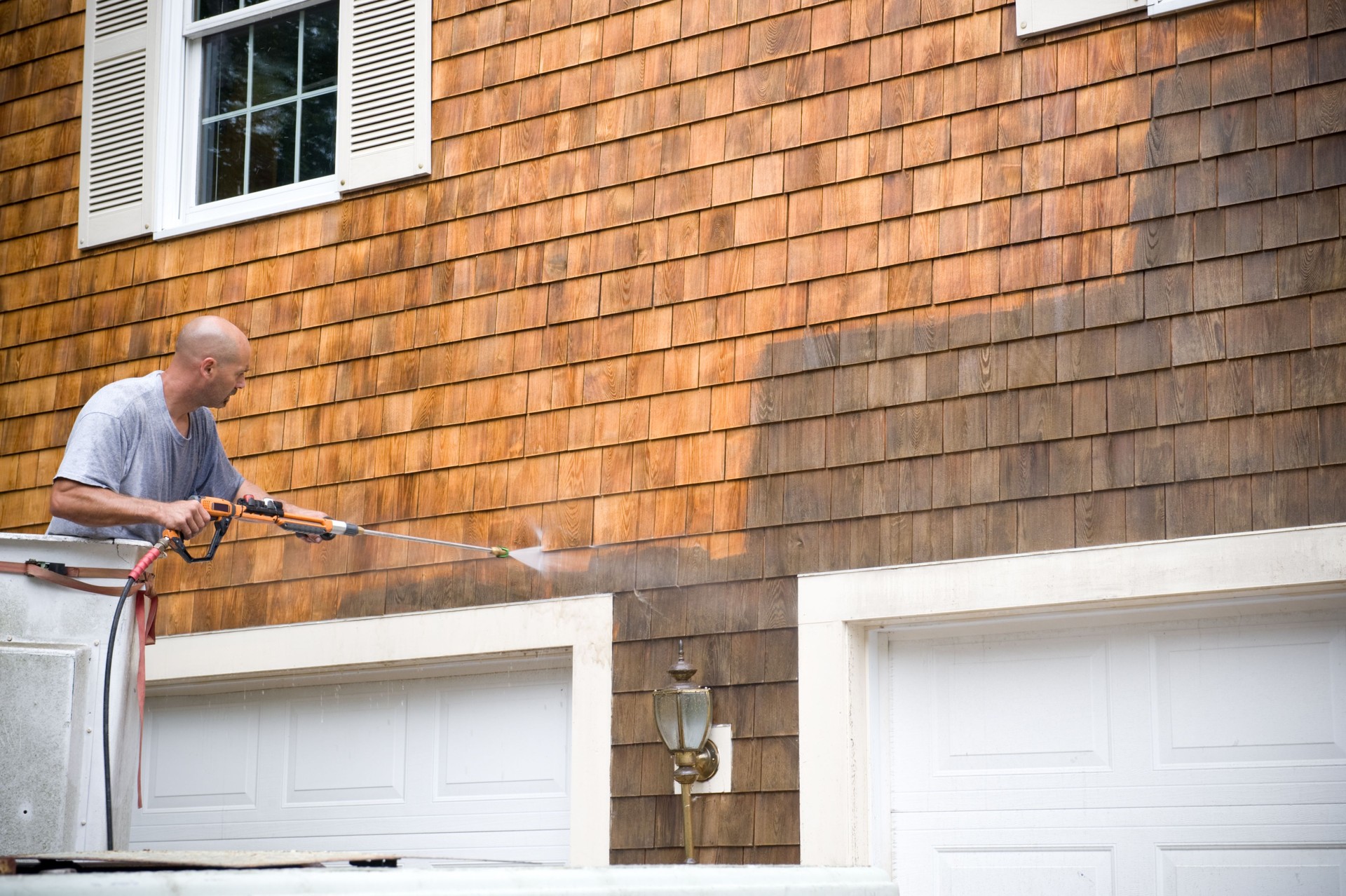 Man Powerwashing a house