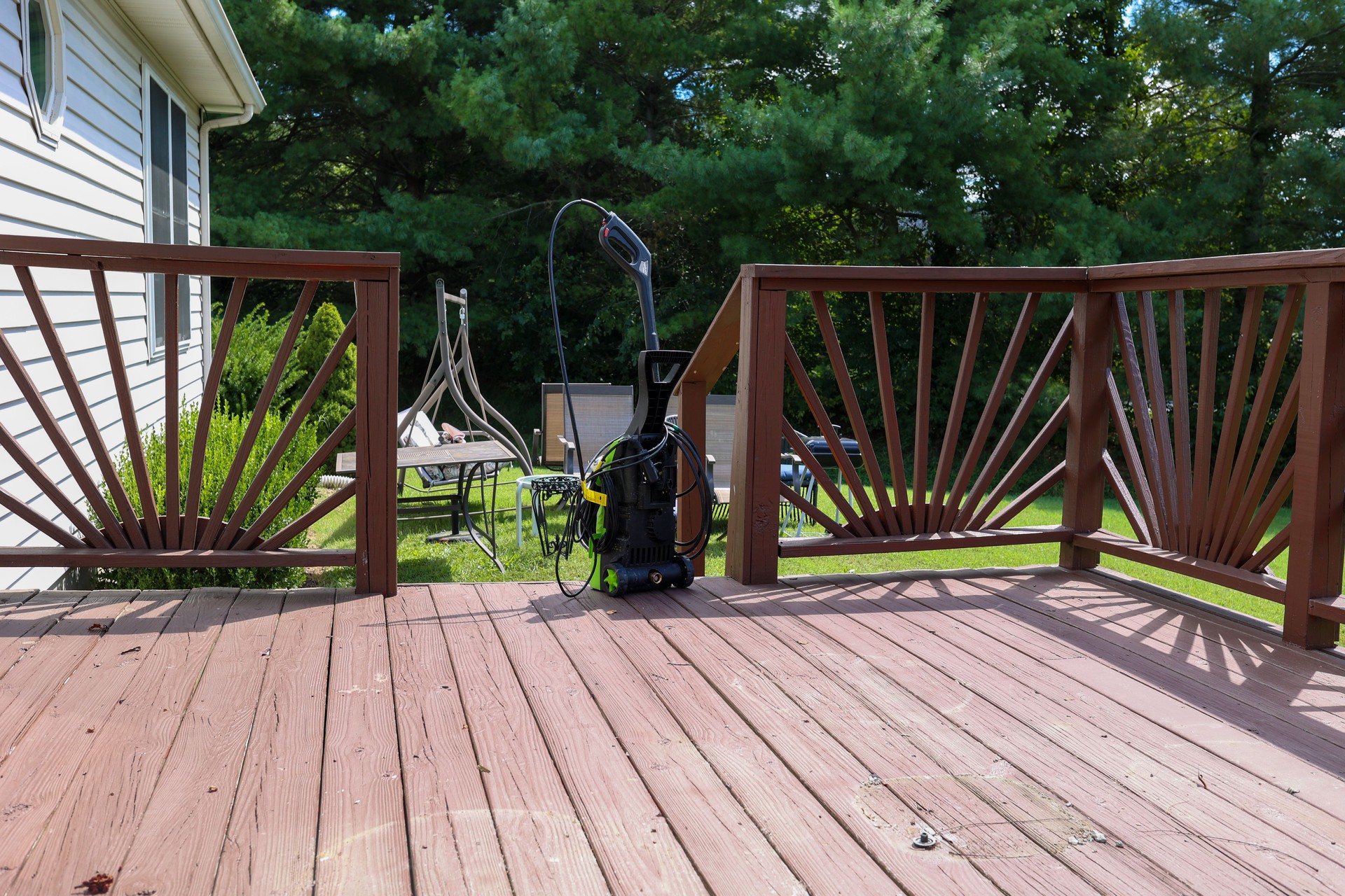 A power washing machine on a wooden patio deck